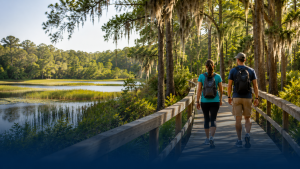 Two hikers on boardwalk by marshland