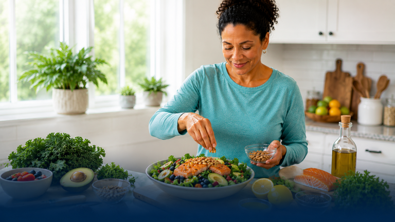 Woman sprinkling seeds on salad in kitchen
